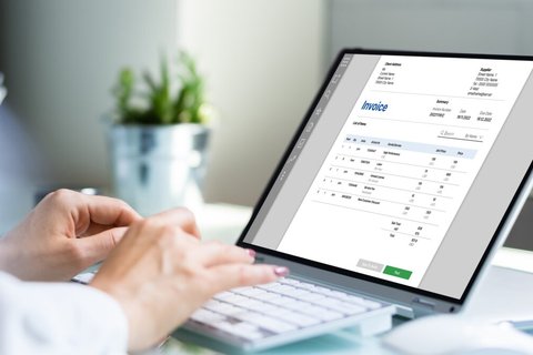 Une personne sur son ordinateur portable ouvre des factures