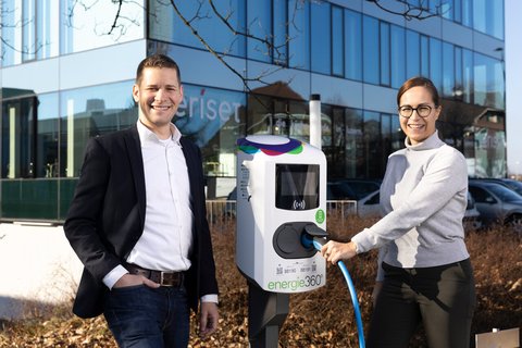 Zwei Mitarbeitende von Energie 360° mit charge@work-Ladesäule, einer Ladestation für Elektroautos von Energie 360°