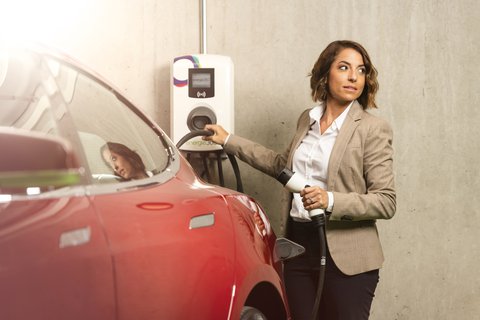 Une femme utilise les bornes d'Energie 360 pour recharger sa voiture électrique