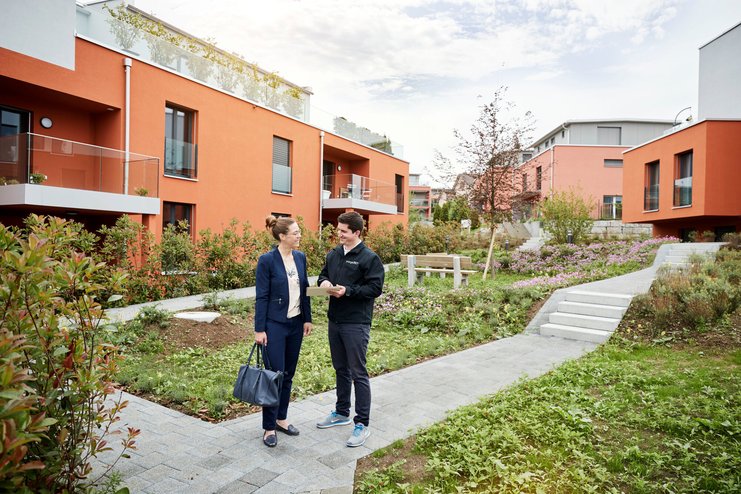 Une femme se fait conseiller sur l’efficacité énergétique de son bien immobilier dans un jardin