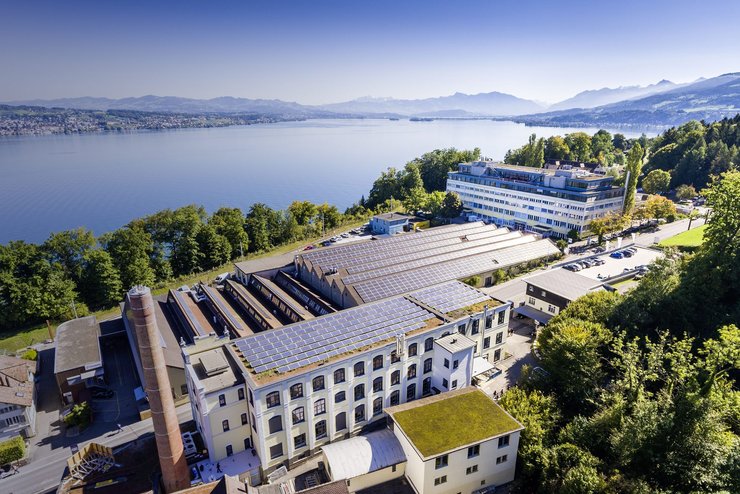 Das Tuwagareal in Wädenswil. Auf den Dächern sind Solarpanels zu sehen, im Hintergrund der Zürichsee.
