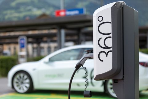 Borne de recharge électrique d’Energie 360° avec une gare CFF en arrière-plan