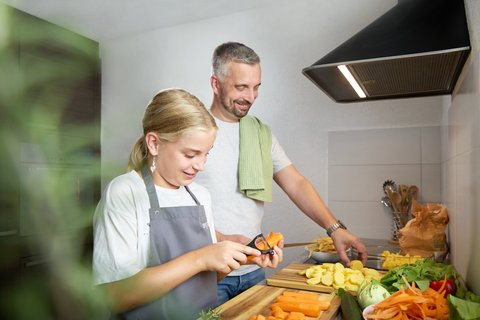 Mann und Kind rüsten Karotten
