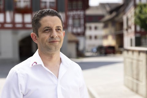 Arsim Gashi, Chef de projet Vente réseaux thermiques chez Energie 360°, se tient devant les célèbres jolies maisons à colombages de Bülach.