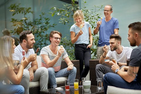 Des membres du personnel d’Energie 360° dégustent une glace pendant une pause de travail et discutent avec passion