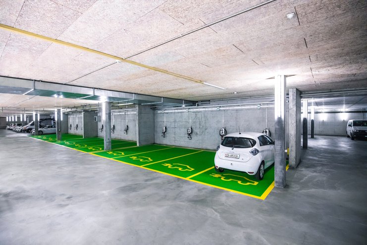 Ein Renault Zoe Elektroauto lädt an einer Wallbox in einer Tiefgarage