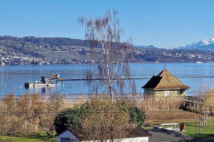 Seeufer mit kleinem Häuschen und Seewasserleitung auf dem See parallel zum Ufer