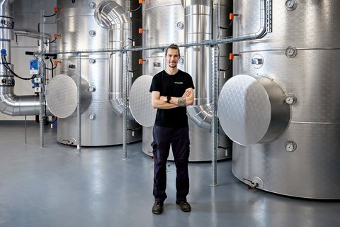 Tim Strebel, Servicetechniker Energie 360°, steht beim Wärmespeicher des Energieverbunds Thalwil