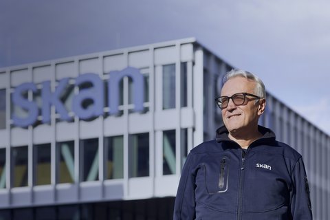 Antonio Nocera, Head Facility Management der Skan AG, steht neben einem Flottenfahrzeug vor dem Firmengebäude in Allschwil