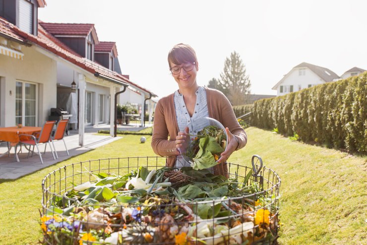 Frau steht an ihrem Kompost