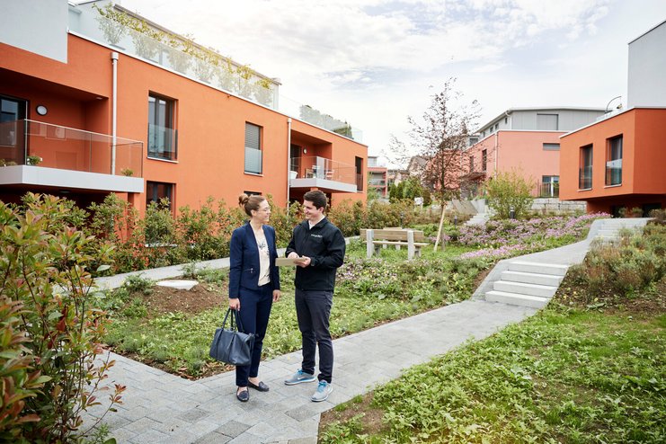 Eine Frau lässt sich im Garten zur Energieeffizienz ihrer Immobilie beraten