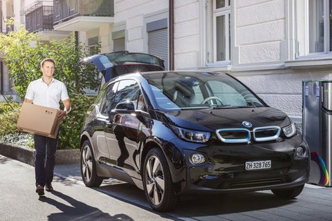 Une BMW i3 se trouve à côté d’une borne de recharge pour voitures électriques