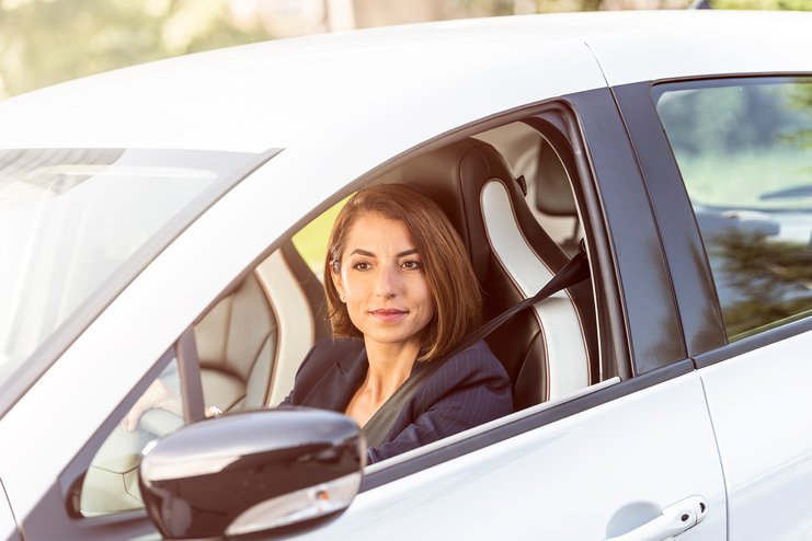 Eine Frau fährt ein Elektroauto mit offenem Fenster