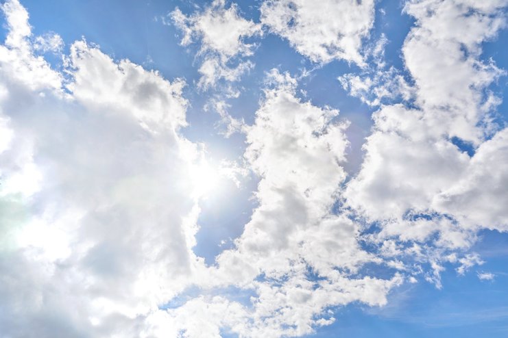 Un ciel bleu avec des nuages blancs pour symboliser l’élimination du CO₂ en Suisse et la voie à suivre pour atteindre les objectifs zéro émission nette.