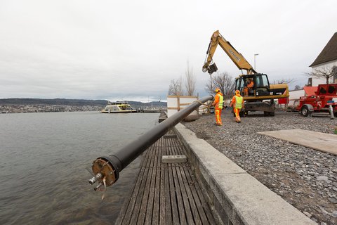 Sur le lac, un ponton tire la conduite pour le captage d’eau à Meilen afin qu’elle puisse ensuite être posée
