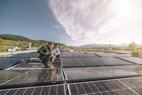 Deux hommes à côté d’une installation solaire sur un grand toit
